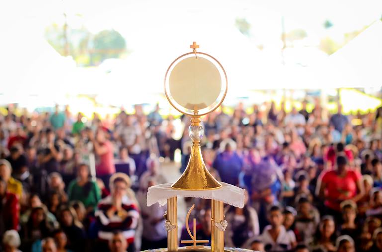 Gold Colored Monstrance before crowd